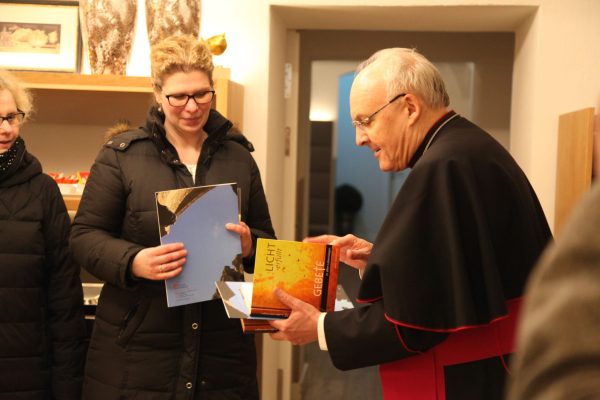 Bischof Dr. Rudolf Voderholzer überreicht Frau Nicole Piehler zum Tauf- und Firmzeugnis ein Gebetbuch. - © Prof. Dr. Veit Neumann